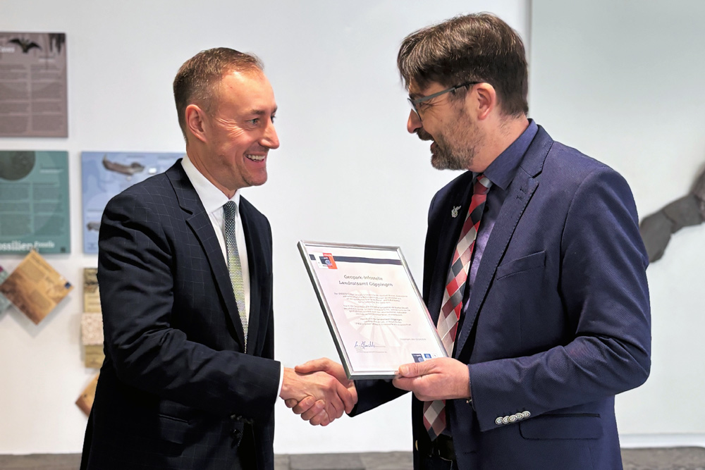 Landrat Möller links im Bild übernimmt eine Urkunde von Bürgermeister Rucks links im Bild.